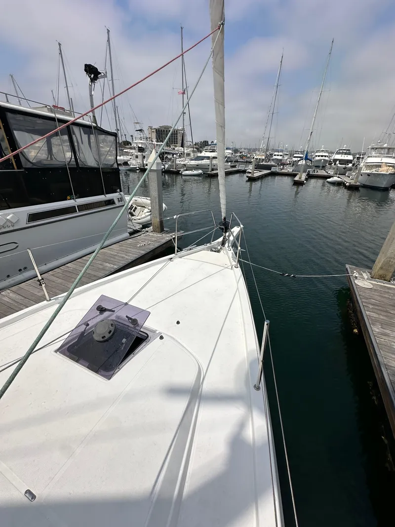 Slide: The Image of 2020 Jeanneau Sun Odyssey 410 sailboat docked in a marina, surrounded by other boats. - 27