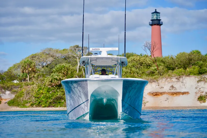 Slide: The Image of 2023 SeaHunter 41 CTS boat near a lighthouse, with lush greenery in the background. - 3