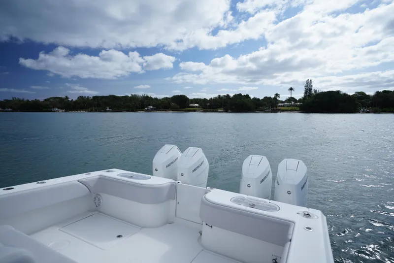 Slide: The Image of 2023 SeaHunter 41 CTS boat with four engines on a calm lake under a cloudy sky. - 5