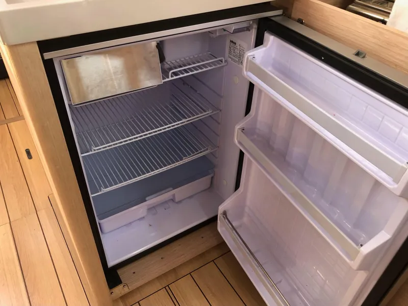 Slide: The Image of Refrigerator inside 2019 Beneteau Oceanis 51.1 yacht, featuring spacious shelving and door compartments. - 25