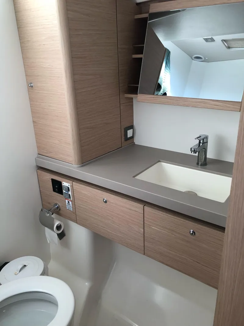 Slide: The Image of 2019 Beneteau Oceanis 51.1 bathroom with modern fixtures and wood cabinetry. - 31
