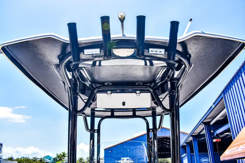 Slide: The Image of 2019 Robalo R242 Center Console boat, viewed from below, showcasing T-top and rod holders. - 5