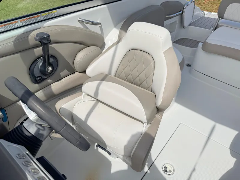 Slide: The Image of 2022 Crownline Eclipse E235 XS boat interior with beige seating and steering wheel. - 12