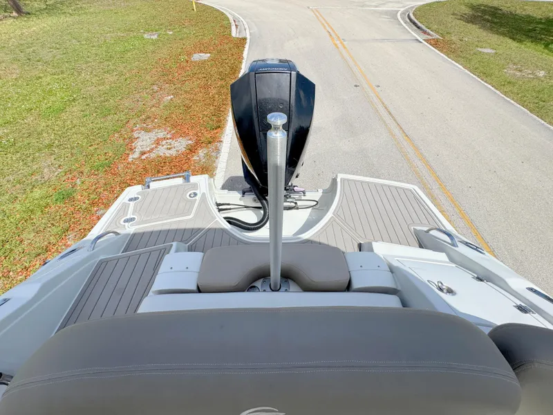 Slide: The Image of 2022 Crownline Eclipse E235 XS boat, rear view with outboard motor on a road. - 25