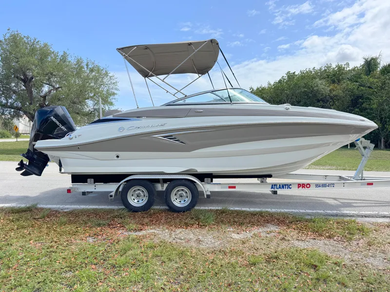 Slide: The Image of 2022 Crownline Eclipse E235 XS boat on trailer, parked outdoors under a clear sky. - 5