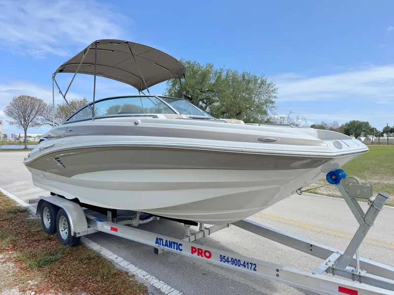 Slide: The Image of 2022 Crownline Eclipse E235 XS boat on trailer, parked outdoors under blue sky. - 6