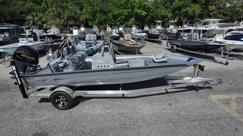 Slide: The Image of 2025 Xpress H20B boat on trailer in marina, surrounded by other boats. - 10