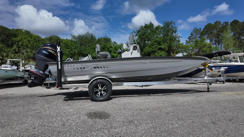 Slide: The Image of 2025 Xpress H20B boat on trailer under clear blue sky. - 12