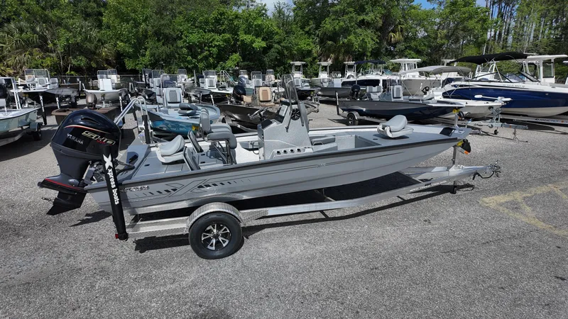 Slide: The Image of 2025 Xpress H20B boat on trailer in marina, surrounded by other boats. - 14
