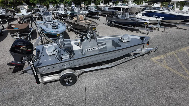 Slide: The Image of 2025 Xpress H20B boat on trailer in a marina parking lot. - 15