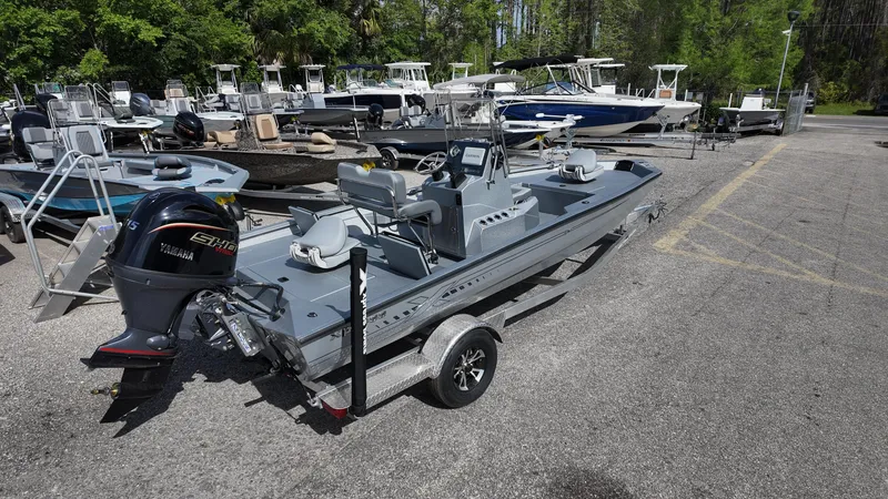 Slide: The Image of 2025 Xpress H20B boat on trailer, parked in marina with other boats. - 18