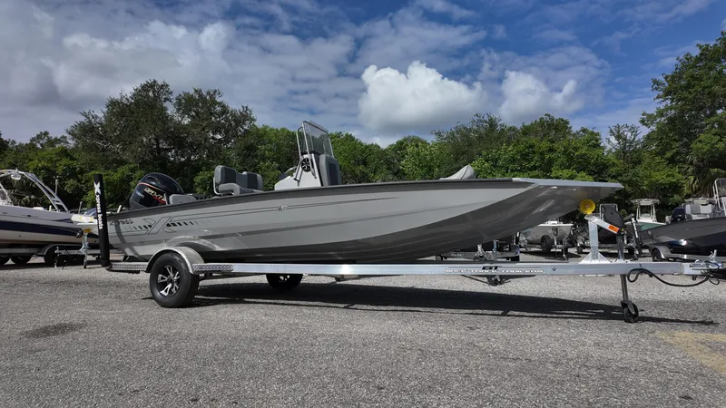 Slide: The Image of 2025 Xpress H20B boat on trailer under a cloudy sky. - 2