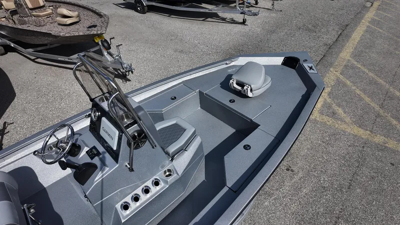 Slide: The Image of 2025 Xpress H20B boat with sleek design and modern console, parked on pavement. - 23