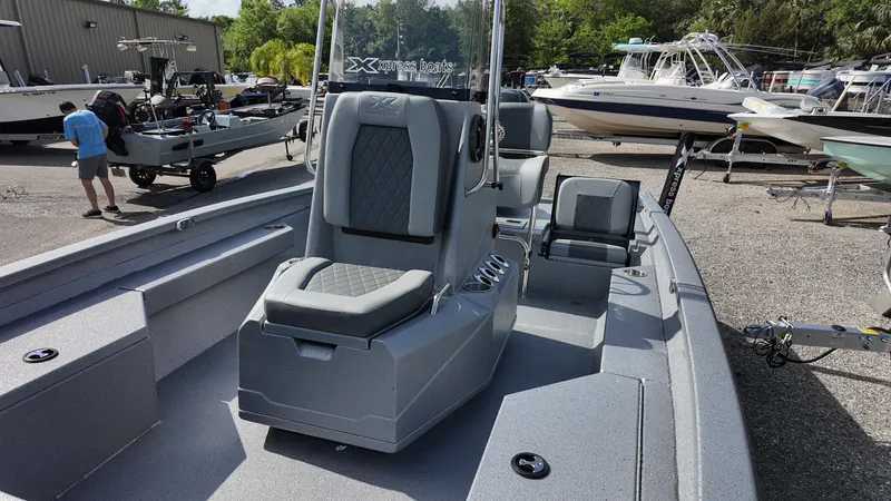 Slide: The Image of 2025 Xpress H20B boat with gray seating, parked in a marina. - 27