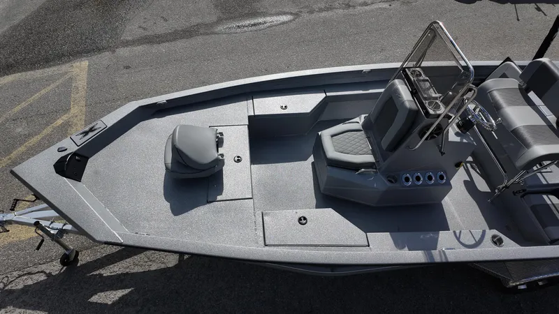 Slide: The Image of 2025 Xpress H20B boat, gray deck, center console, and seating, parked on asphalt. - 29
