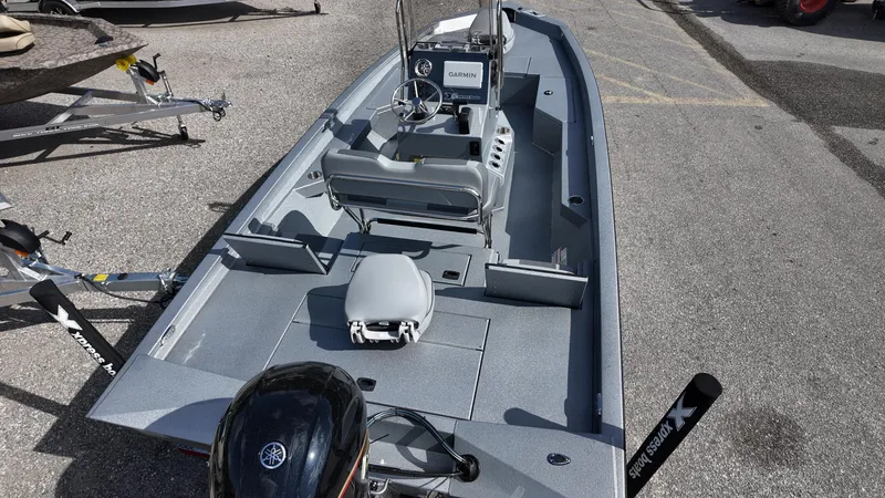 Slide: The Image of 2025 Xpress H20B boat with Yamaha motor, gray interior, and steering console, parked on pavement. - 33