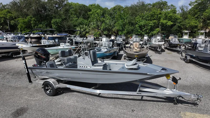 Slide: The Image of 2025 Xpress H20B boat on trailer in marina, surrounded by trees and other boats. - 7