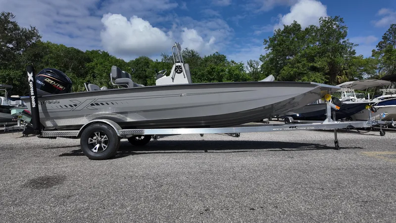 Slide: The Image of 2025 Xpress H20B boat on trailer, parked outdoors under a cloudy sky. - 9