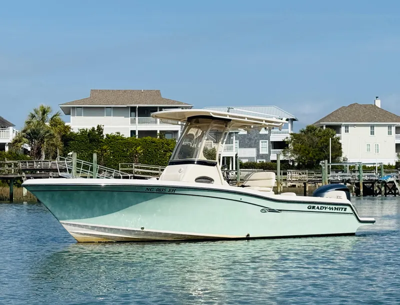 Slide: The Image of 2018 Grady-White Fisherman 216 boat on calm water near waterfront homes. - 3