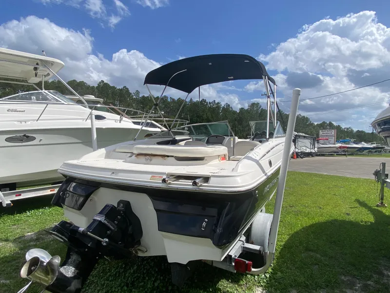 Slide: The Image of 2005 Monterey 194 BR boat with canopy, parked on grass under a blue sky. - 4