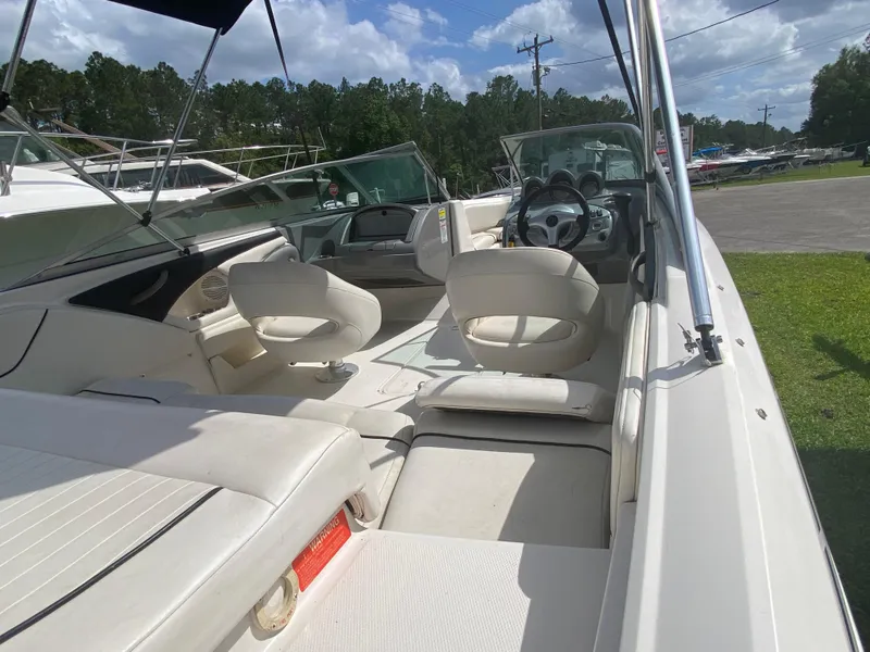 Slide: The Image of 2005 Monterey 194 BR boat interior with white seating and steering wheel, under sunny skies. - 6