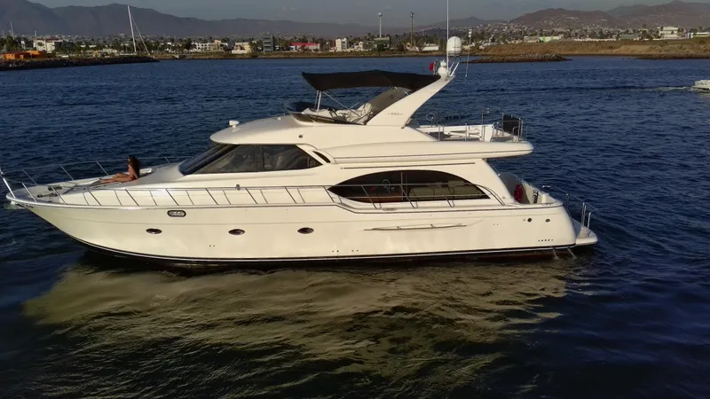 Slide: The Image of 2004 Meridian 580 Pilothouse yacht cruising on calm waters near a coastal city. - 4