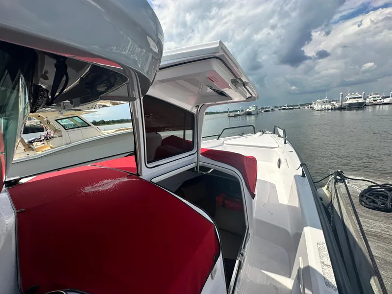 Slide: The Image of Axopar 37 XC Cross Cabin BRABUS LINE 2022, docked with red seating, cloudy sky background. - 10