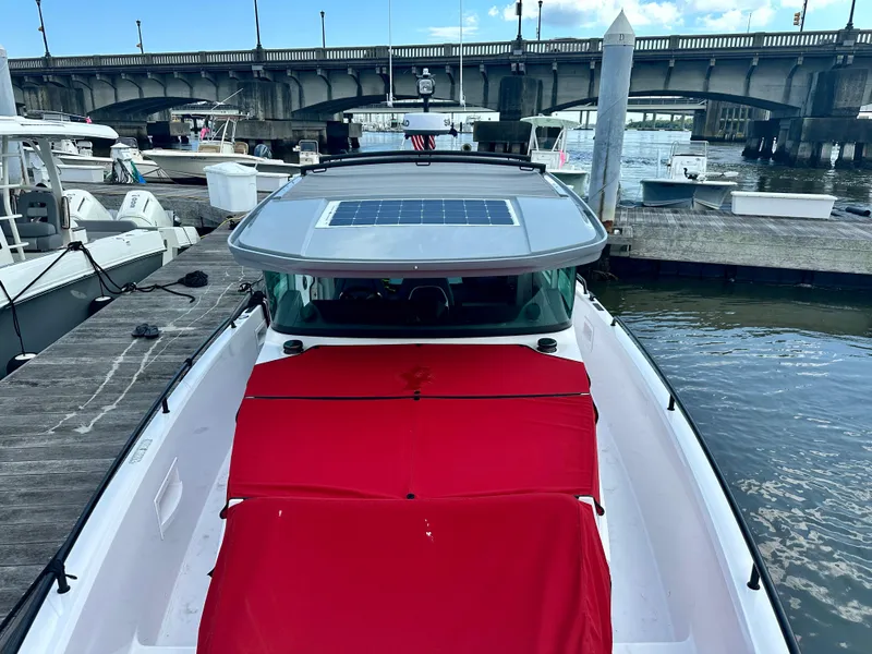 Slide: The Image of 2022 Axopar 37 XC Cross Cabin BRABUS LINE docked, featuring a red cover and solar panel. - 13