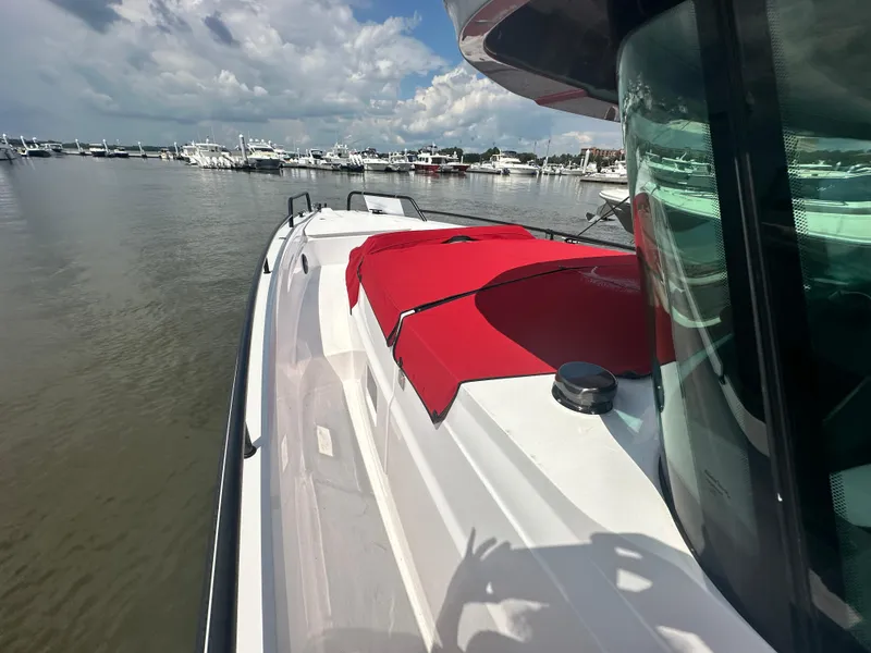 Slide: The Image of 2022 Axopar 37 XC Cross Cabin BRABUS LINE boat docked, featuring red seating and sleek design. - 19