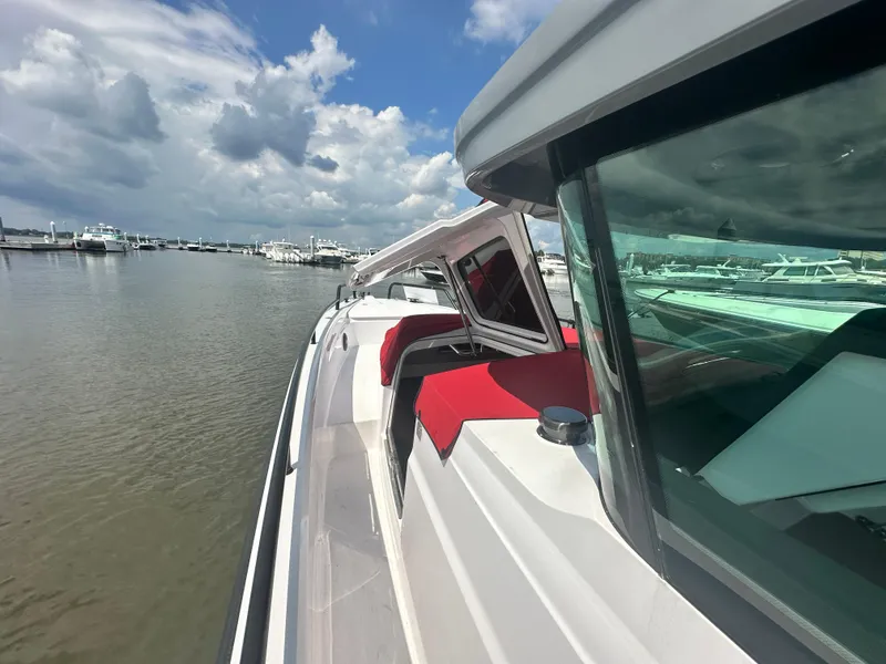 Slide: The Image of 2022 Axopar 37 XC Cross Cabin BRABUS LINE docked, featuring sleek design and red seating. - 21