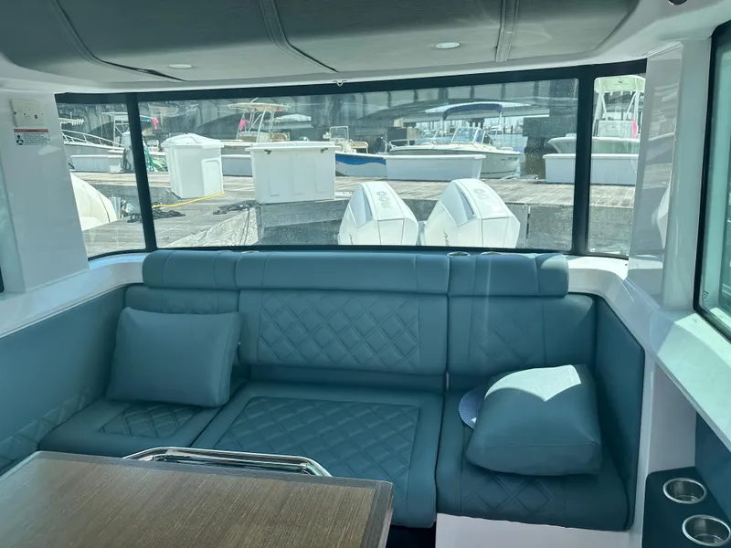 Slide: The Image of Interior of 2022 Axopar 37 XC Cross Cabin BRABUS LINE with plush seating and marina view. - 32