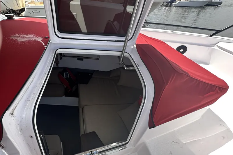 Slide: The Image of 2022 Axopar 37 XC CROSS CABIN interior with red cover and seating area. - 48