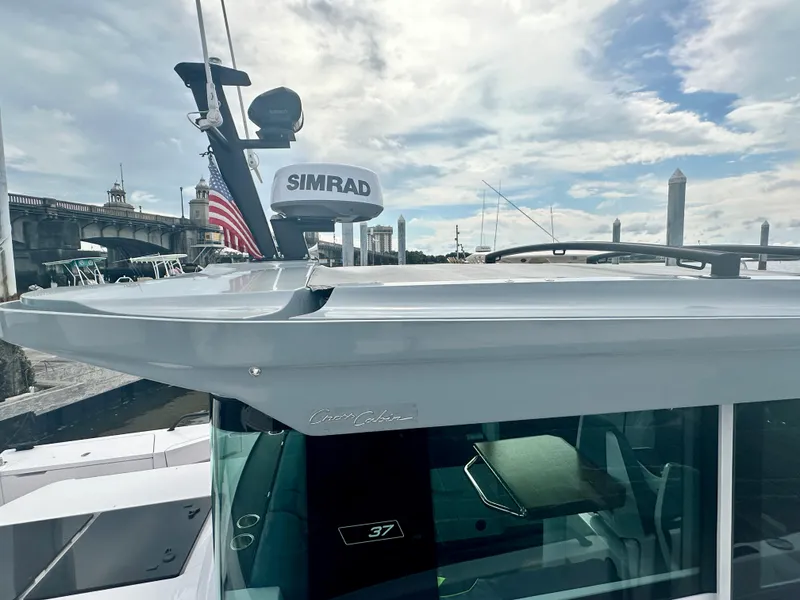 Slide: The Image of 2022 Axopar 37 XC Cross Cabin BRABUS LINE with Simrad radar, docked under a cloudy sky. - 8