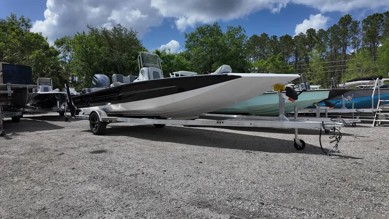 Slide: The Image of 2025 Xpress H22B boat on trailer, parked outdoors under cloudy sky. - 1