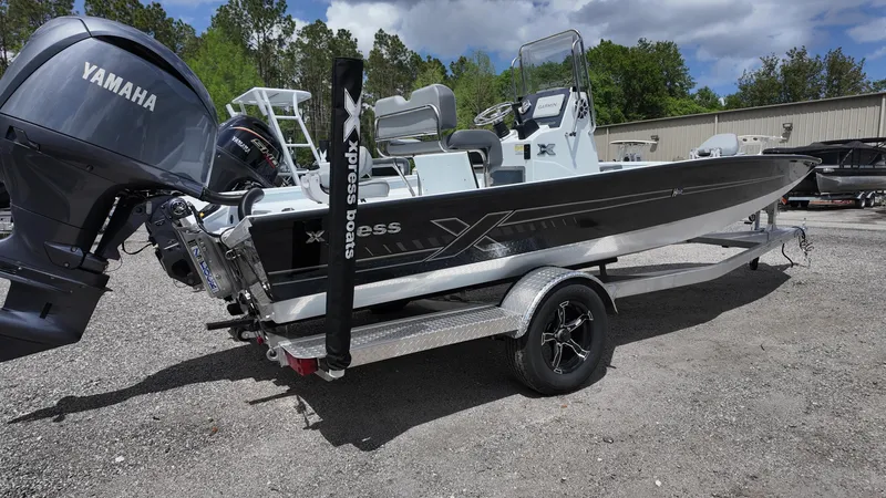 Slide: The Image of 2025 Xpress H22B boat with Yamaha engine on a trailer, parked outdoors. - 12