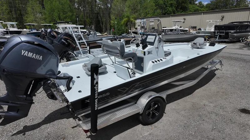 Slide: The Image of 2025 Xpress H22B boat with Yamaha engine on a trailer, parked outdoors. - 13