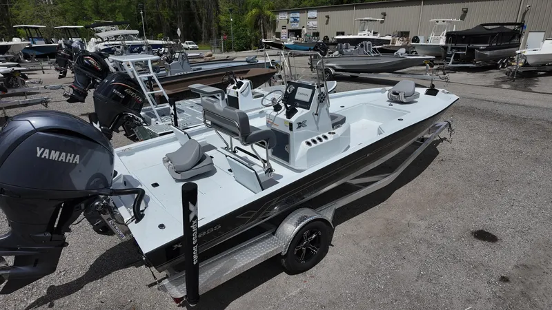 Slide: The Image of 2025 Xpress H22B boat with Yamaha engine, parked on a trailer in a marina. - 14