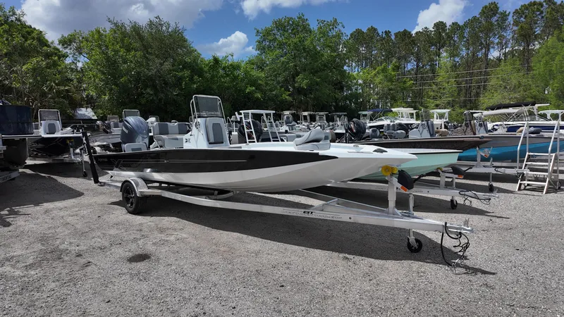 Slide: The Image of 2025 Xpress H22B boat on trailer, parked outdoors with other boats. - 2