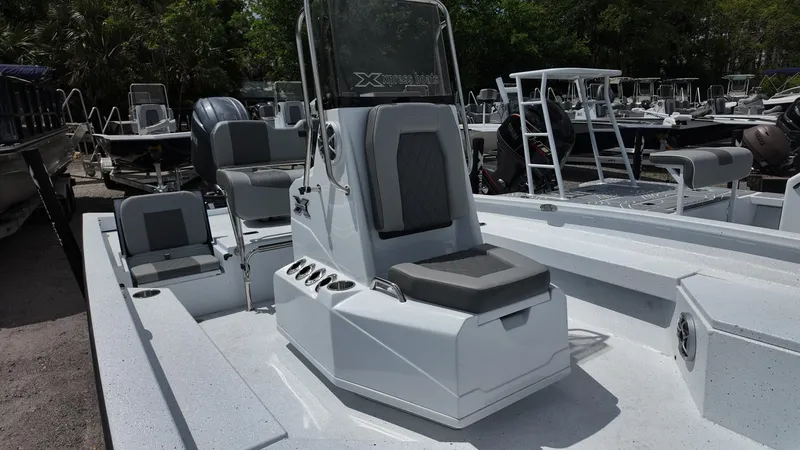 Slide: The Image of 2025 Xpress H22B boat interior with seating and console, docked outdoors. - 21