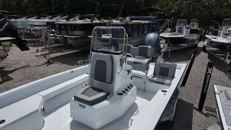 Slide: The Image of 2025 Xpress H22B boat with center console, parked among other boats. - 24