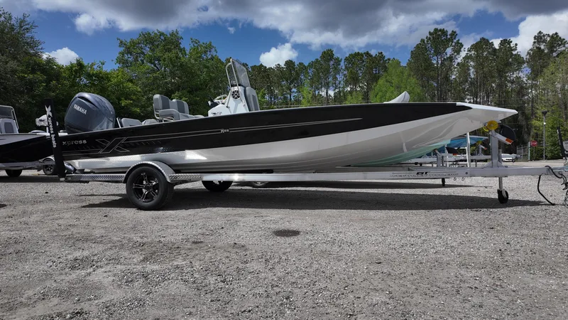 Slide: The Image of 2025 Xpress H22B boat on trailer, parked outdoors under cloudy sky. - 7