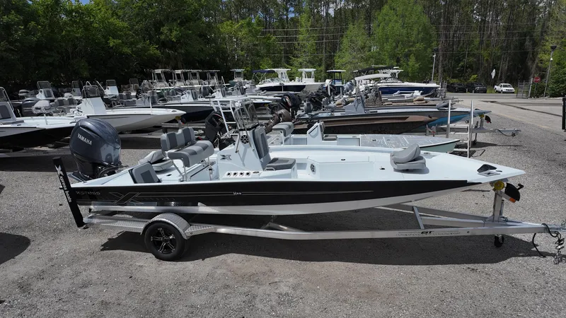 Slide: The Image of 2025 Xpress H22B boat on trailer, surrounded by other boats, in outdoor dealership. - 9
