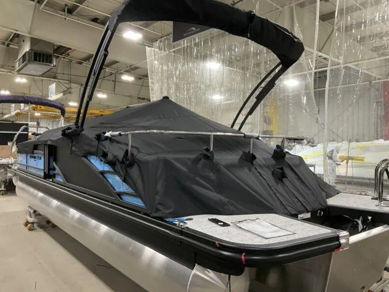 Slide: The Image of 2025 Bennington R Bowrider Swingback 24 RTSB pontoon boat with cover in a warehouse. - 14