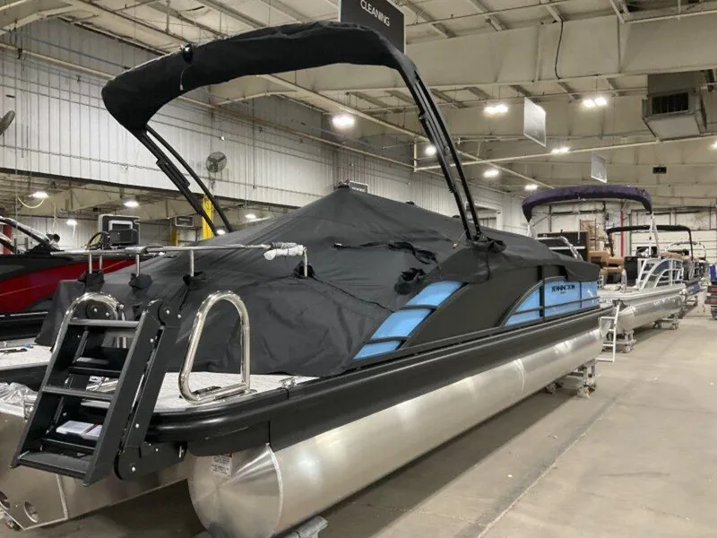 Slide: The Image of 2025 Bennington R Bowrider Swingback 24 RTSB pontoon boat in showroom, covered and ready for display. - 7