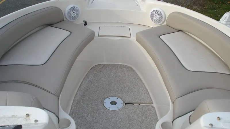 Slide: The Image of 2003 Sea Ray 240 Sundeck interior with cushioned seating and speakers. - 10