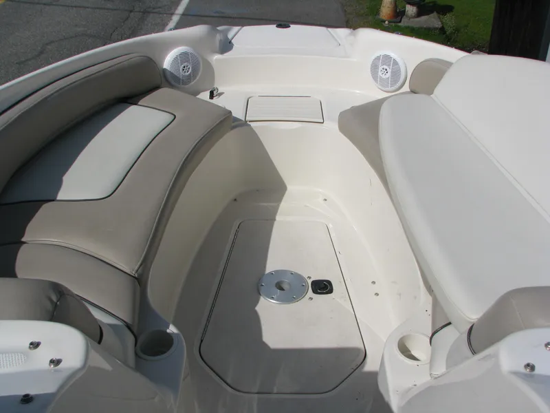 Slide: The Image of 2003 Sea Ray 240 Sundeck interior with beige seating and speakers. - 12