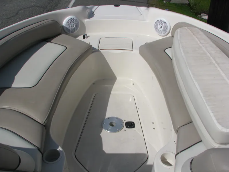 Slide: The Image of 2003 Sea Ray 240 Sundeck interior with beige seating and built-in speakers. - 15