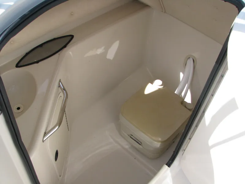 Slide: The Image of 2003 Sea Ray 240 Sundeck interior with portable toilet and storage space. - 16