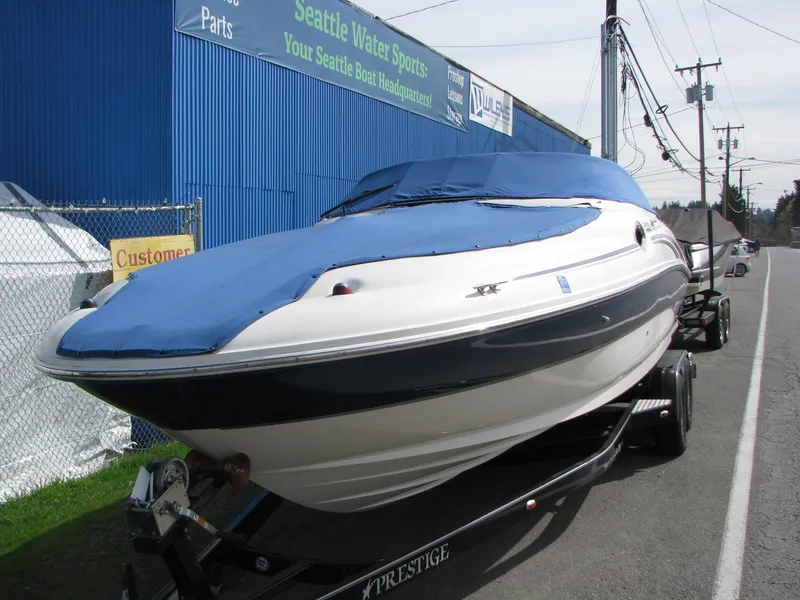 Slide: The Image of 2003 Sea Ray 240 Sundeck boat on trailer, covered, outside Seattle Water Sports. - 2