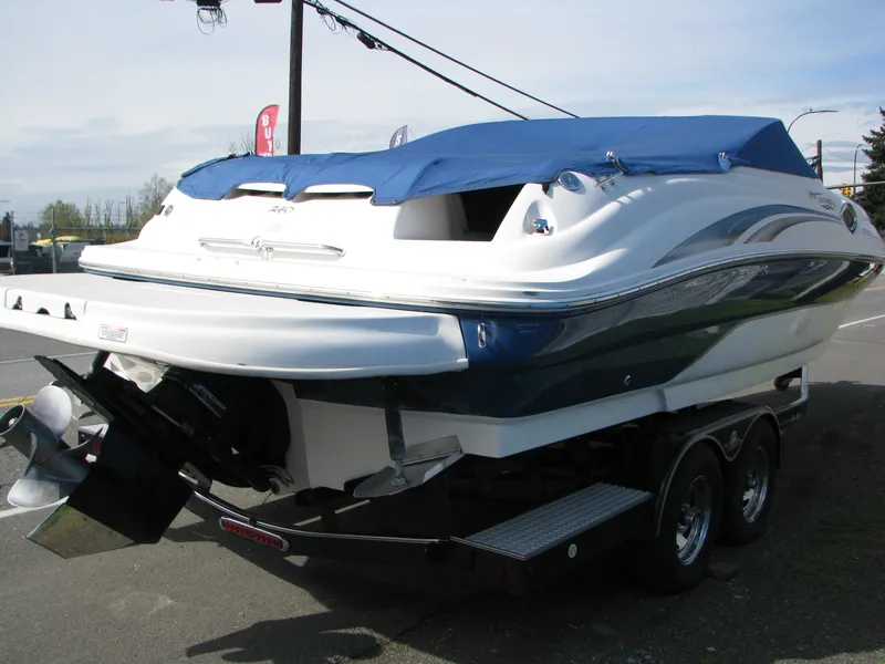 Slide: The Image of 2003 Sea Ray 240 Sundeck boat on trailer with blue cover, parked outdoors. - 3